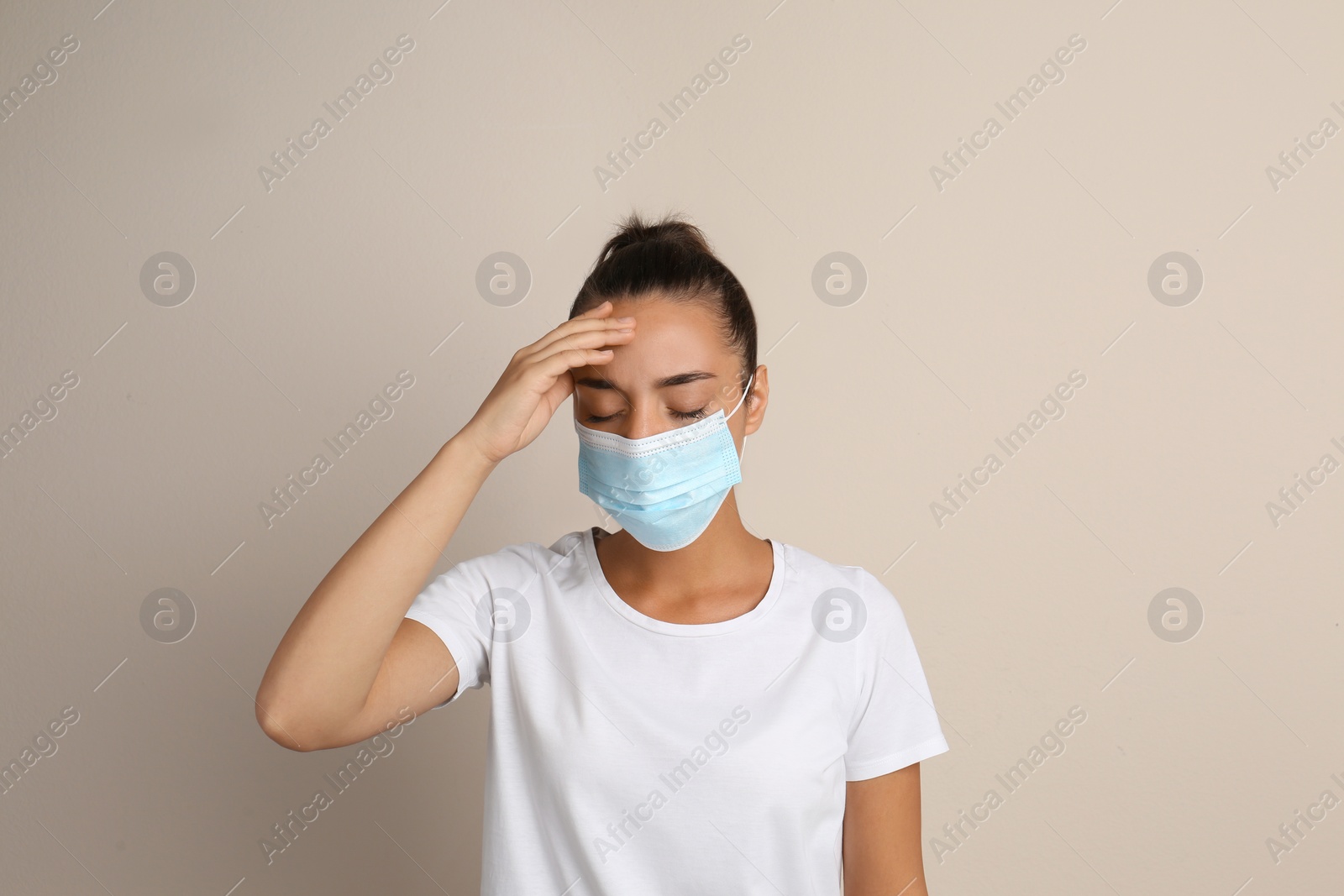 Photo of Stressed woman in protective mask on beige background. Mental health problems during COVID-19 pandemic