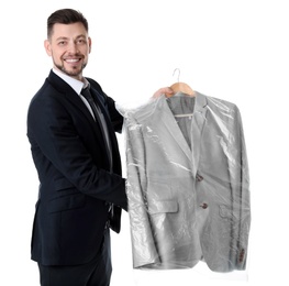 Photo of Young businessman holding hanger with jacket in plastic bag on white background. Dry-cleaning service