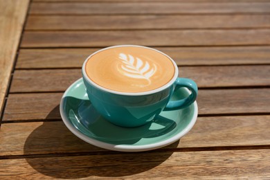 Cup of aromatic hot coffee on wooden table