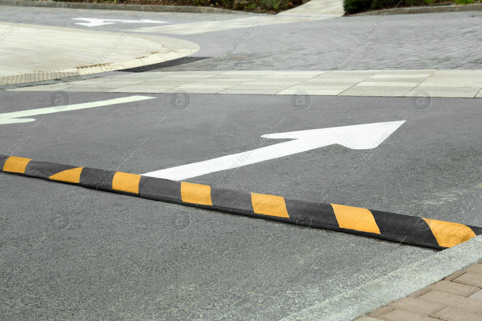 Photo of Striped speed bump on street. Road safety