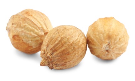 Three dried coriander seeds on white background