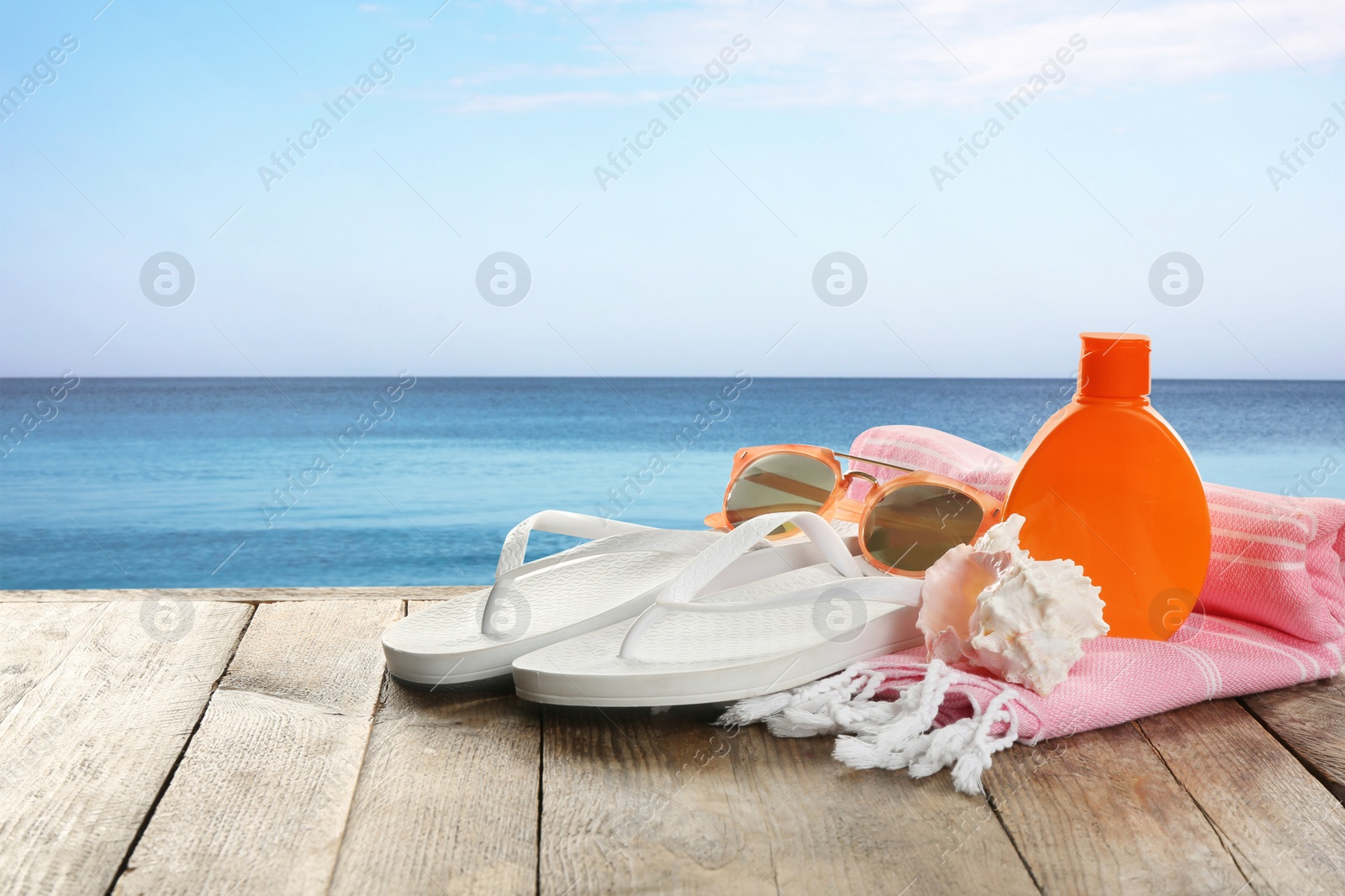 Image of Beach accessories on wooden surface near sea, space for text