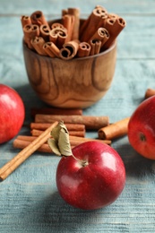 Photo of Fresh apples and cinnamon sticks on wooden table