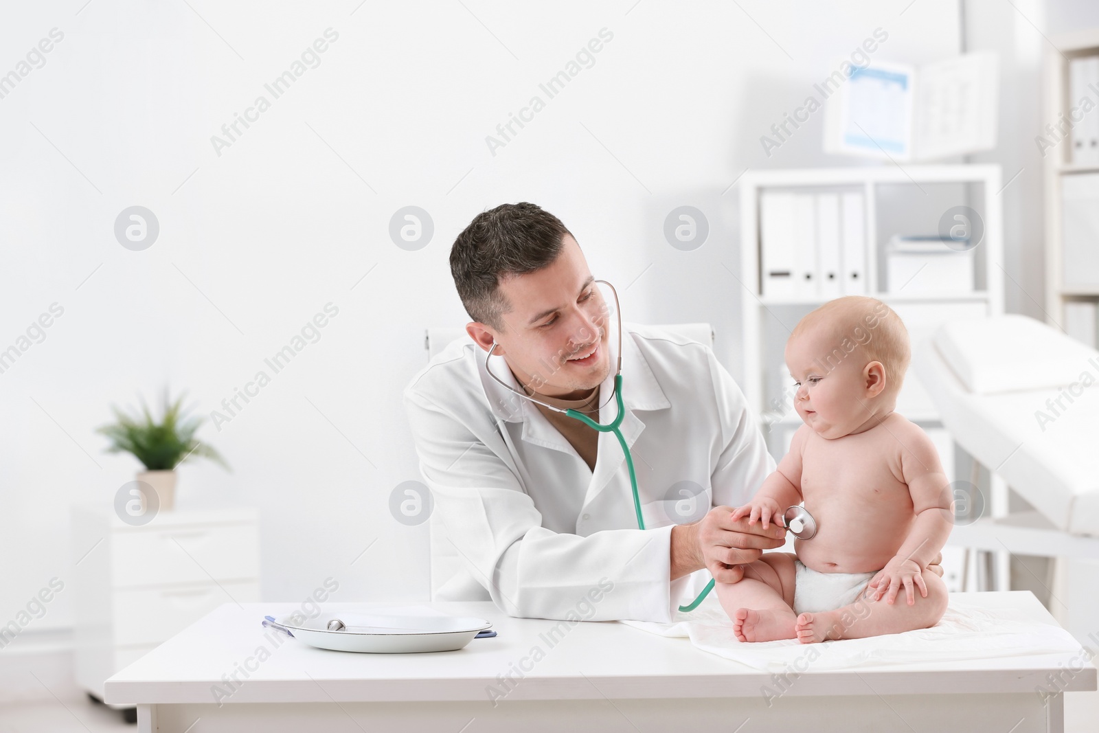 Photo of Children's doctor examining baby with stethoscope in hospital