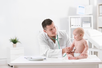 Photo of Children's doctor examining baby with stethoscope in hospital