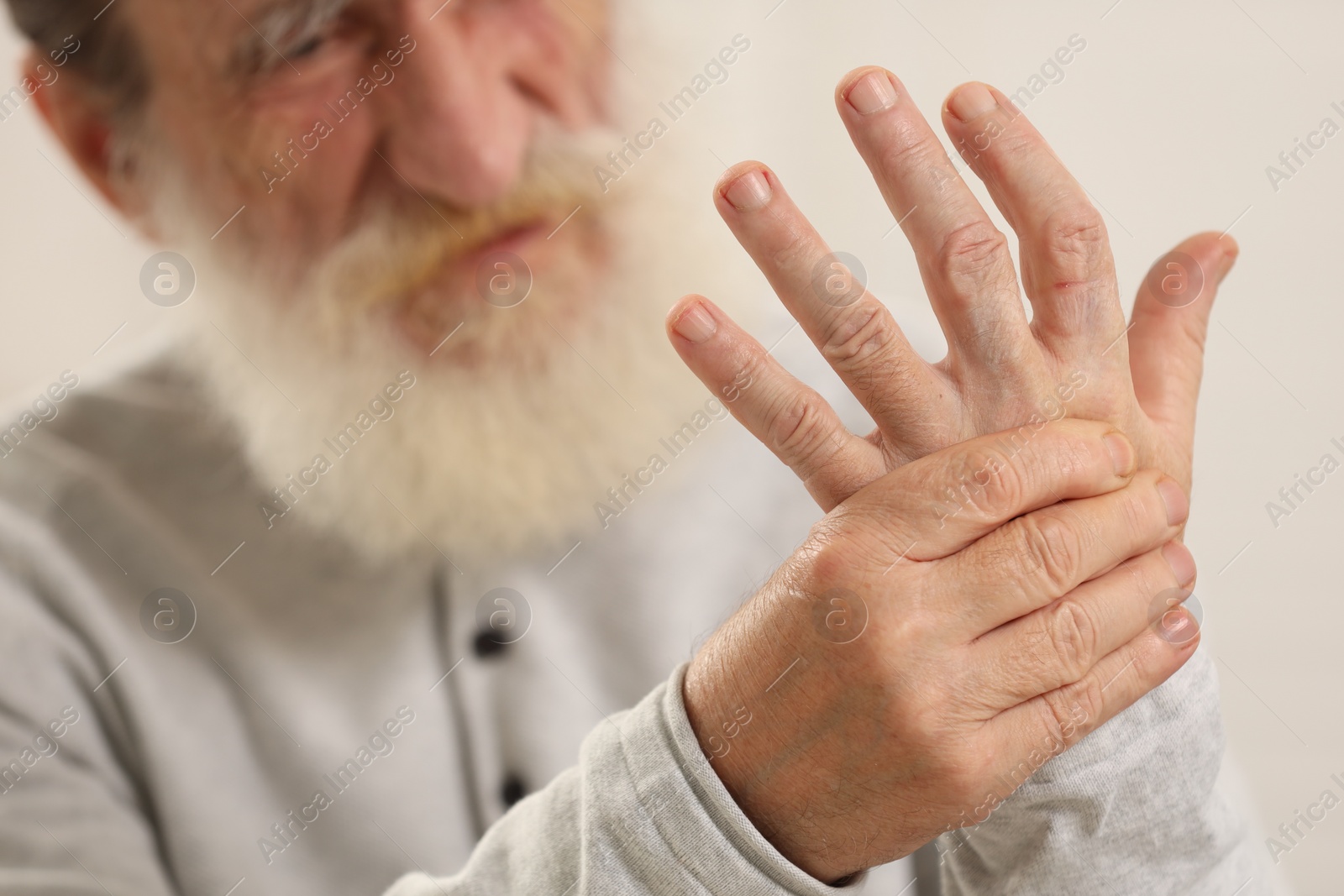 Photo of Senior man suffering from pain in hand, closeup. Rheumatism symptom