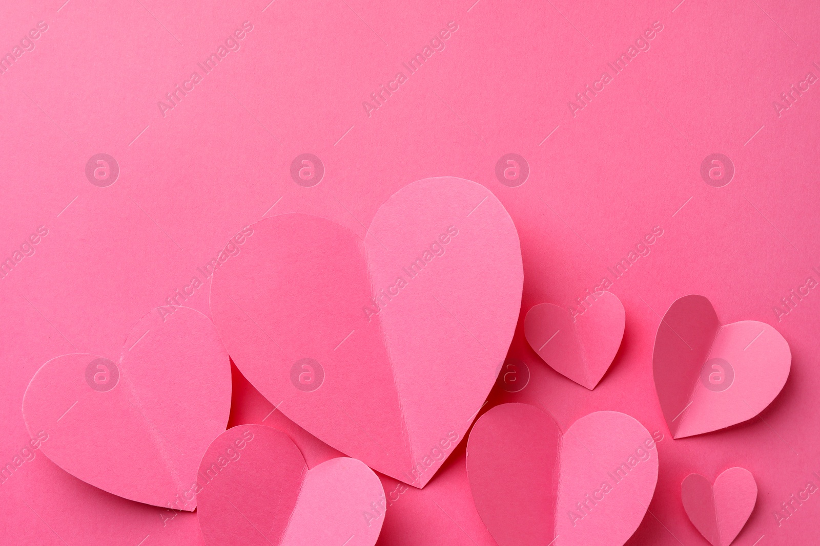 Photo of Paper hearts on pink background, flat lay. Space for text