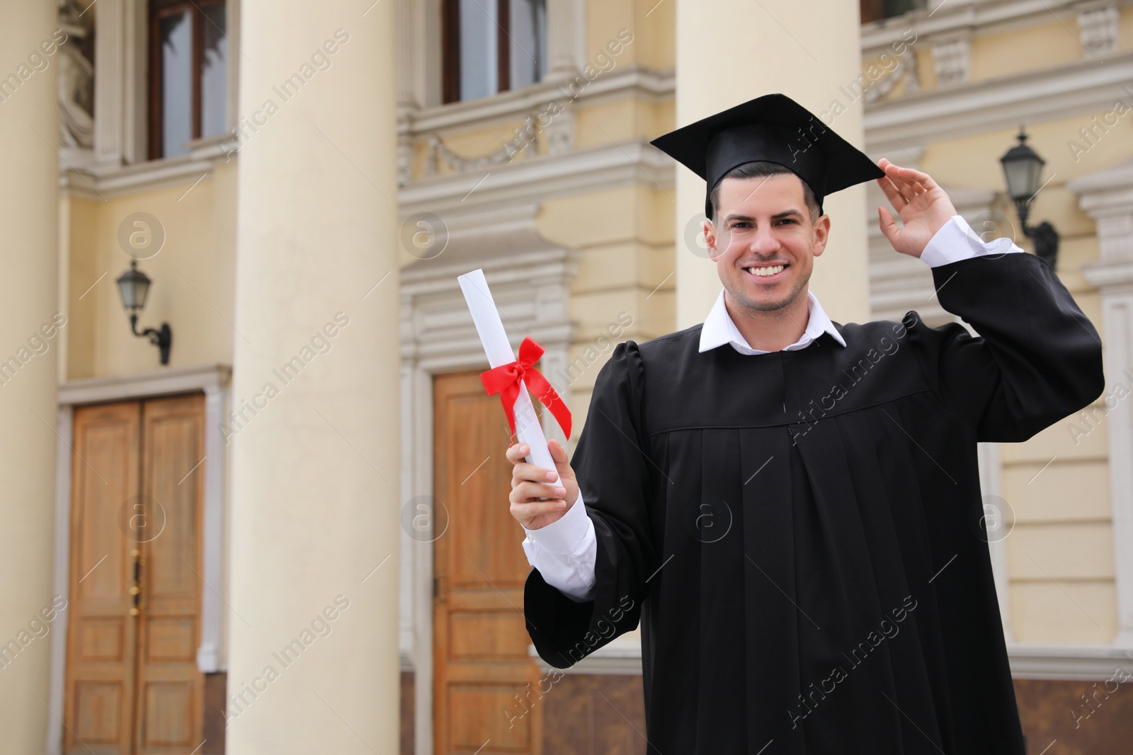 Photo of Happy student with diploma after graduation ceremony outdoors. Space for text