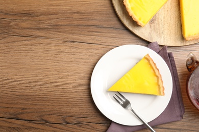Photo of Delicious homemade lemon pie on wooden table, flat lay. Space for text