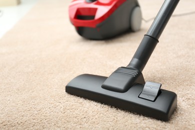 Removing dirt from carpet with modern vacuum cleaner indoors