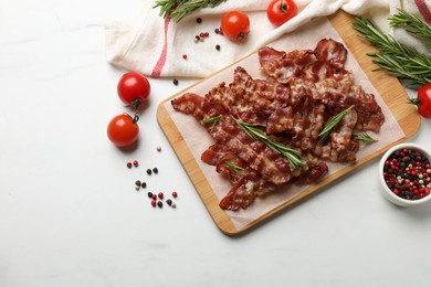 Photo of Slices of tasty fried bacon with different spices and tomatoes on light table, flat lay. Space for text