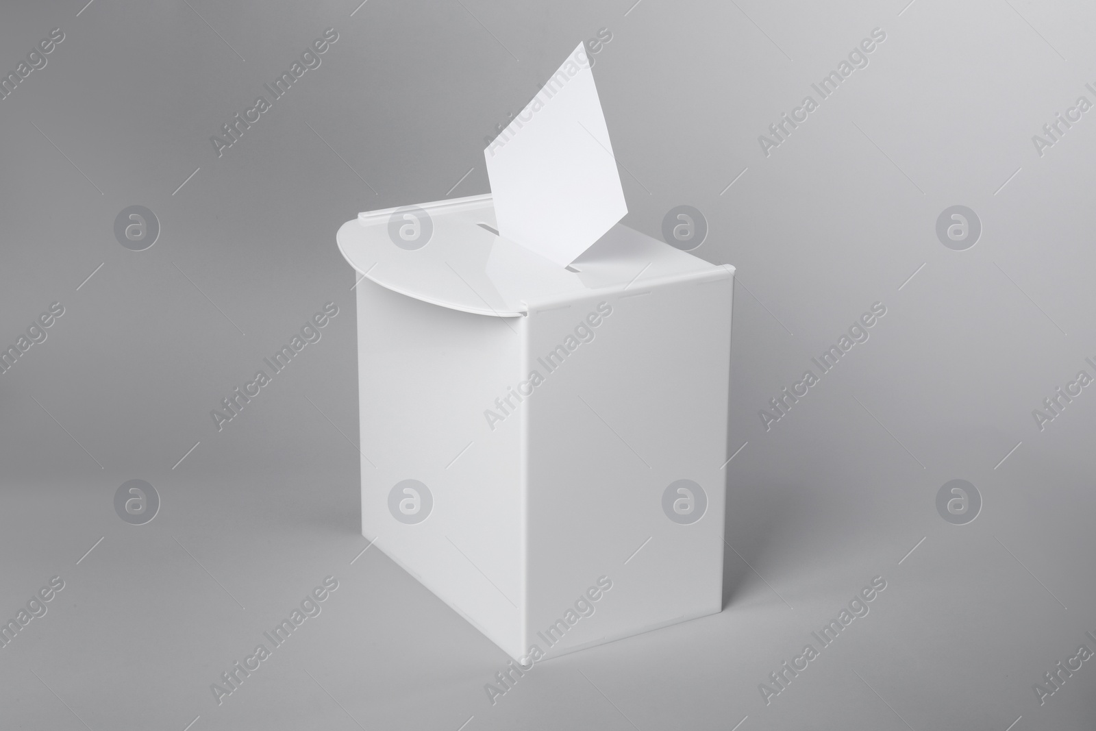 Photo of Ballot box with vote on light grey background. Election time