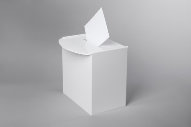 Ballot box with vote on light grey background. Election time