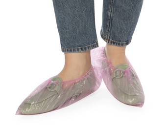 Woman wearing shoe covers onto her mules against white background, closeup