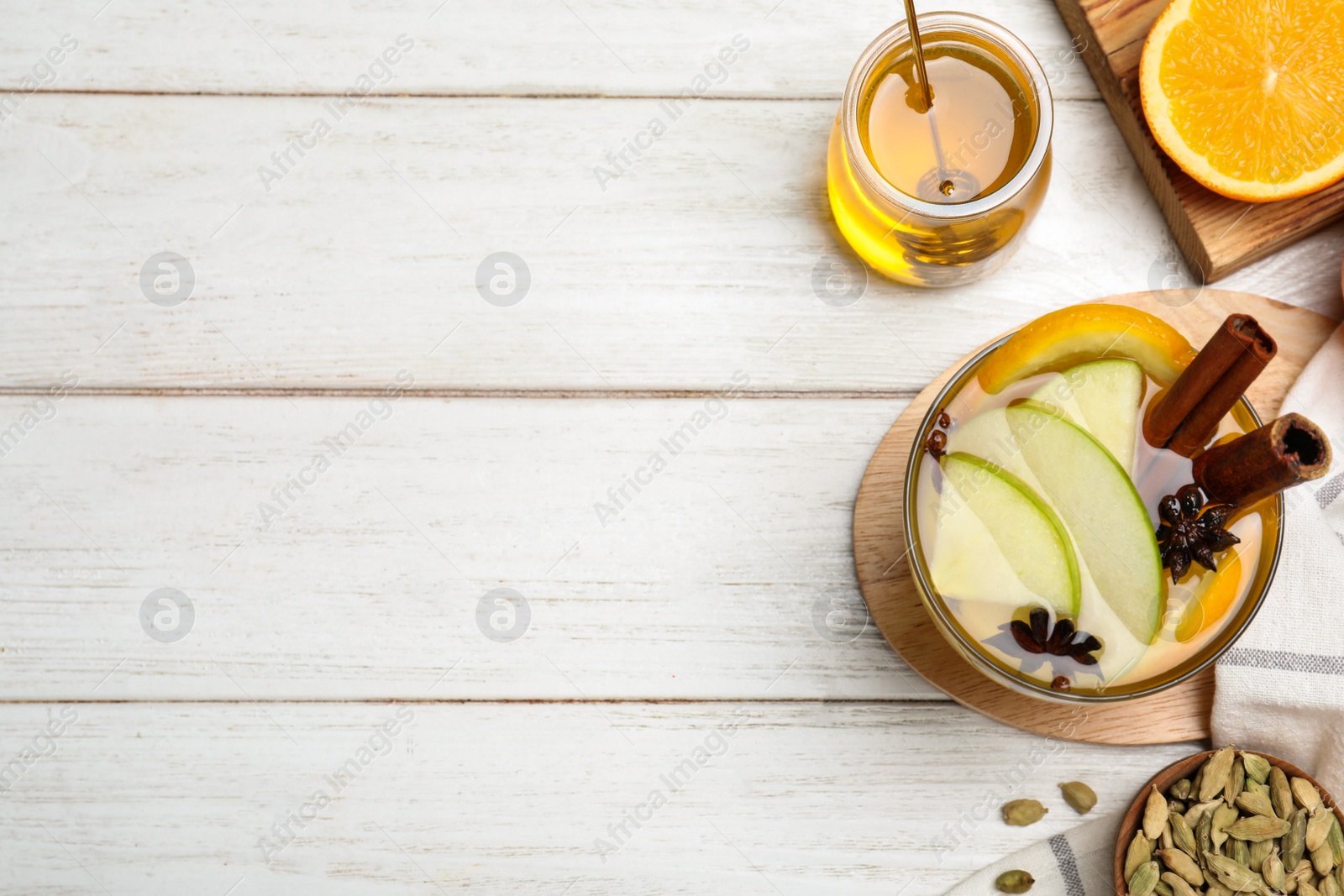 Photo of Aromatic white mulled wine on wooden table, flat lay. Space for text