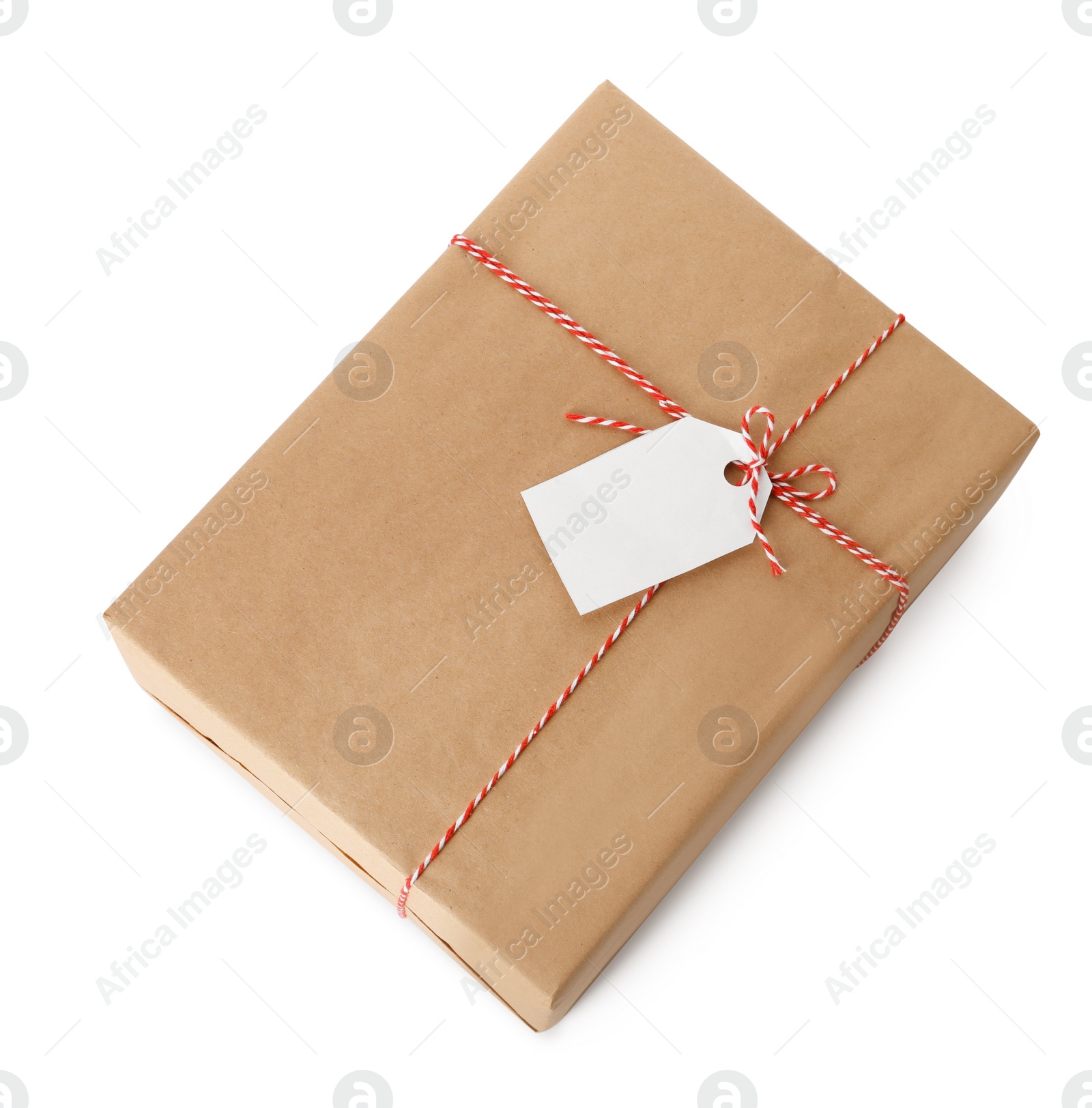 Photo of Gift box wrapped in kraft paper with bow and tag isolated on white