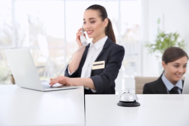 Photo of Service bell and female receptionists in hotel