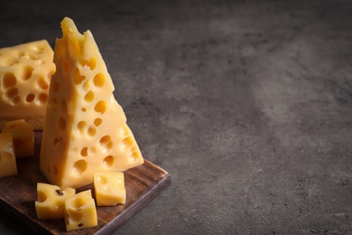 Photo of Tasty fresh cheese on dark grey table, space for text