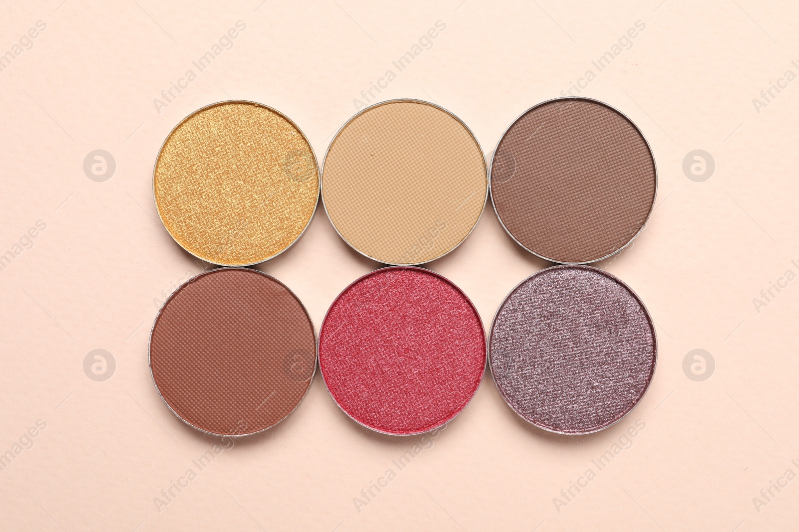 Photo of Beautiful eye shadow refill pans on beige background, flat lay