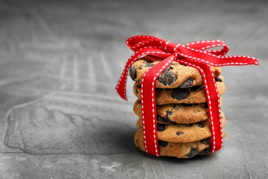 Photo of Stack of cookies with chocolate chips on grey background, space for text