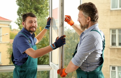 Construction workers installing new window in house