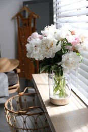 Bouquet of beautiful peony flowers on window sill indoors