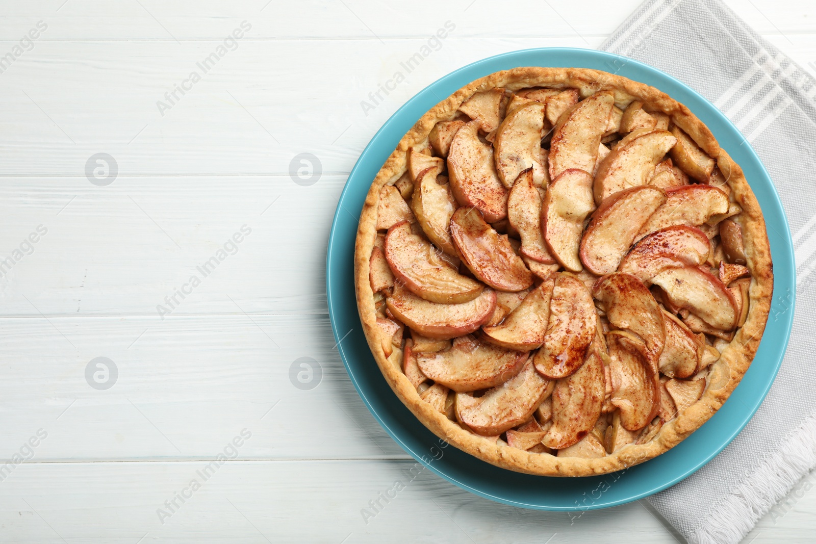 Photo of Delicious apple pie on white wooden table, top view. Space for text