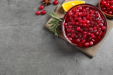Flat lay composition with cranberry sauce on grey table, space for text