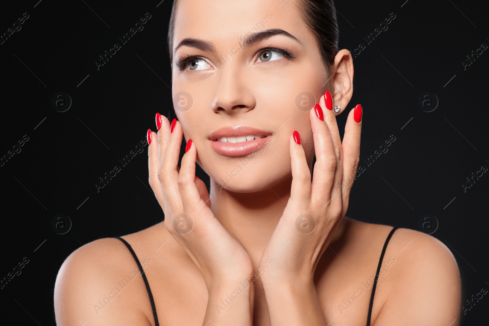 Photo of Beautiful young woman with bright manicure on black background, closeup. Nail polish trends