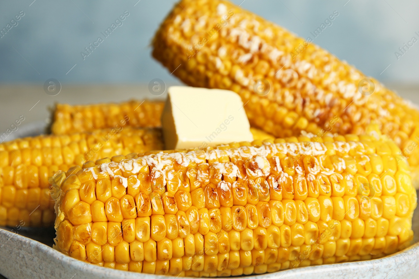 Photo of Delicious grilled corn with butter on plate, closeup