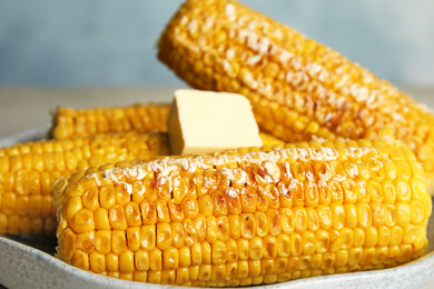Delicious grilled corn with butter on plate, closeup