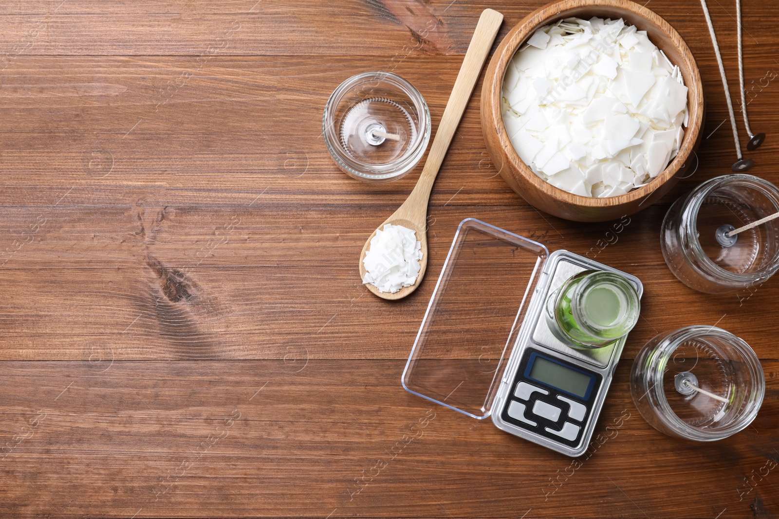 Photo of Flat lay composition with homemade candles ingredients on wooden background, space for text