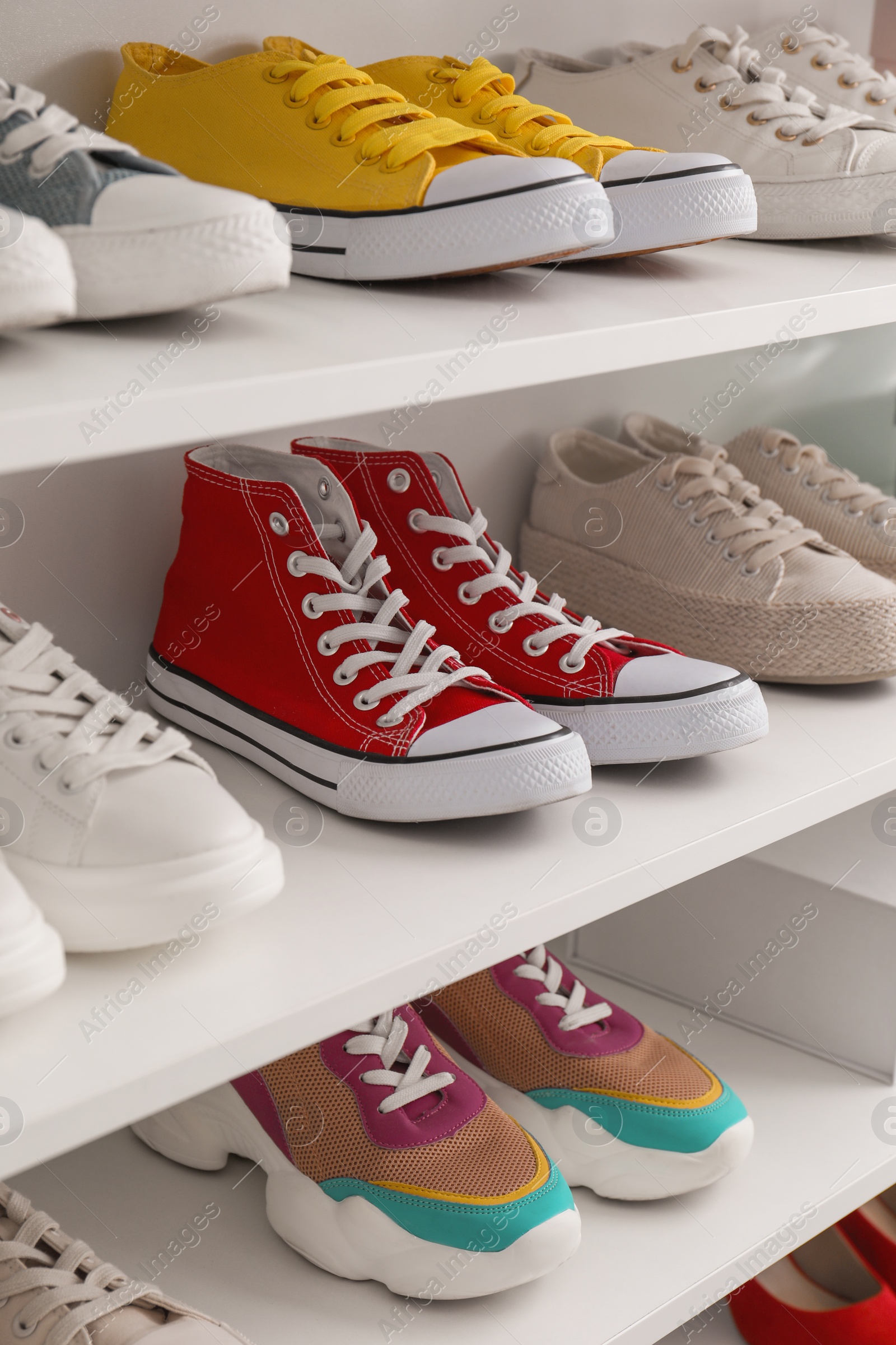 Photo of White shelving unit with collection of colorful sneakers