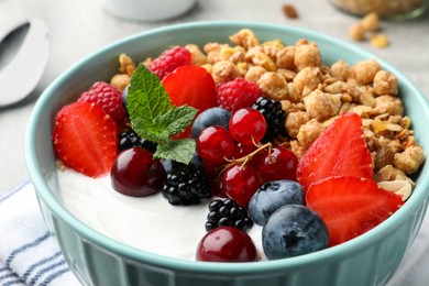 Photo of Bowl with tasty granola and berries on table, closeup. Healthy meal