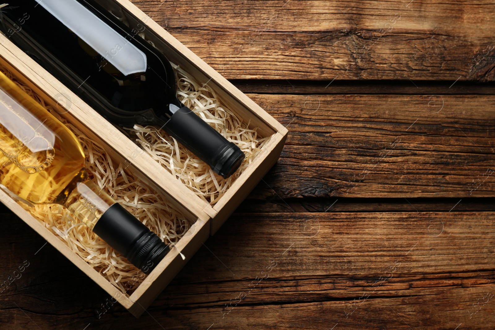 Photo of Boxes with bottles of wine on wooden background, flat lay. Space for text