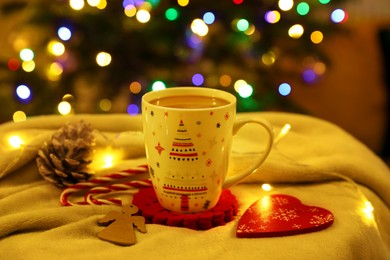 Photo of Cup of delicious hot cocoa and beautiful Christmas decor on white cloth
