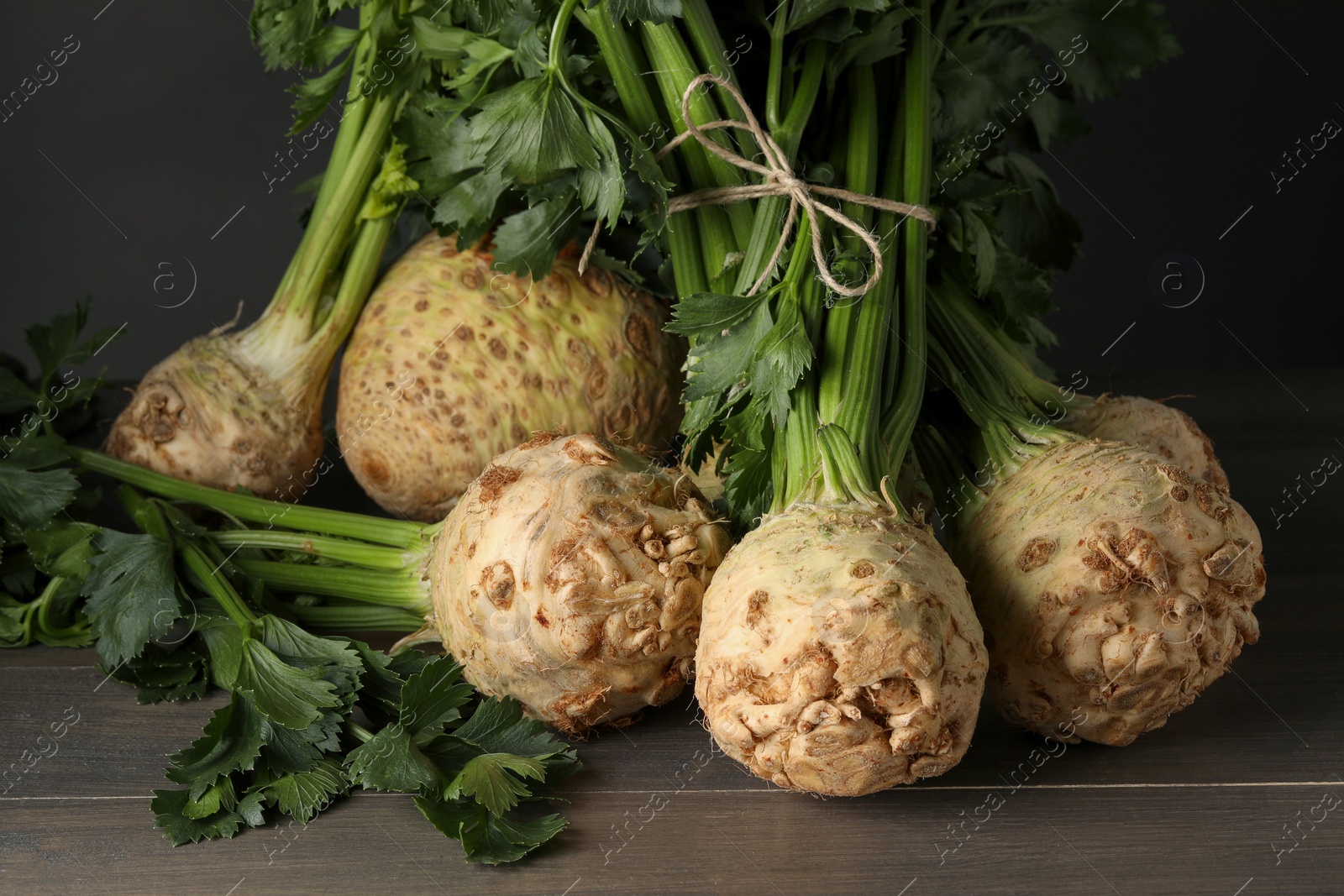 Photo of Fresh raw celery roots on wooden table