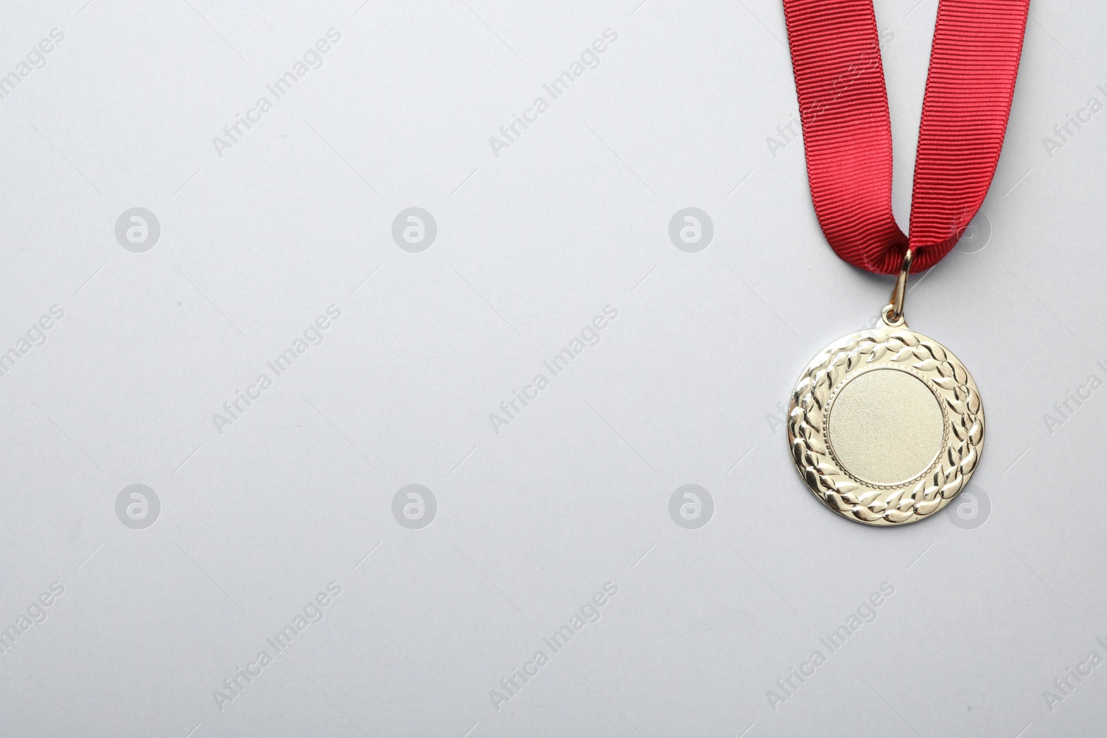 Photo of Gold medal with space for design on light background, top view. Victory concept