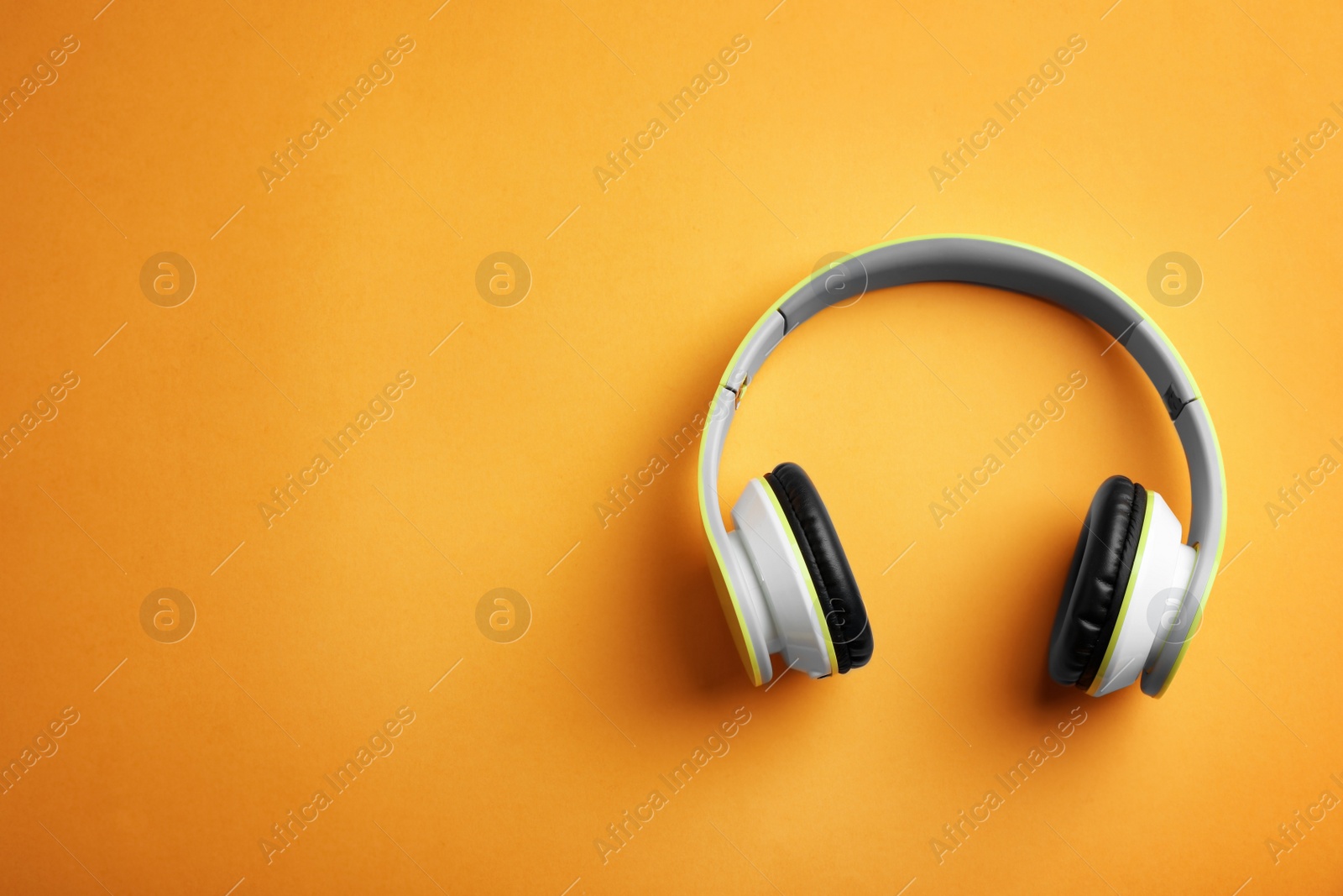 Photo of Wireless headphones on color background, top view. Space for text