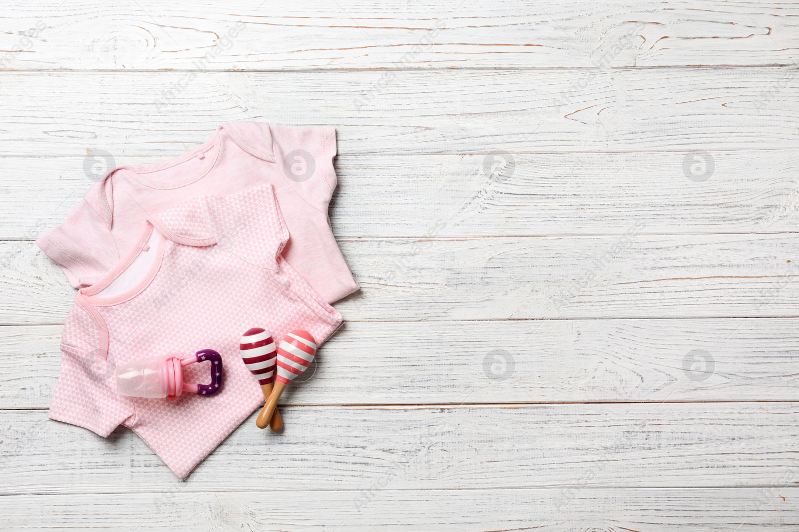 Photo of Flat lay composition with baby clothes and accessories on wooden background. Space for text