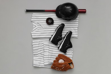 Photo of Baseball uniform and other sports equipment on white background, flat lay