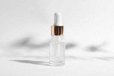 Bottle of cosmetic serum on white background