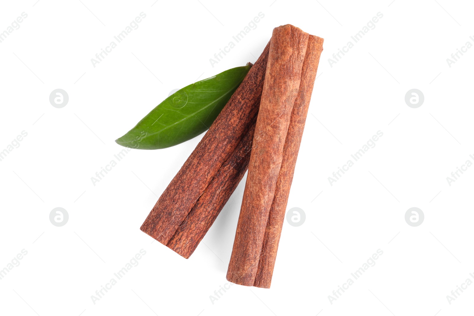 Photo of Cinnamon sticks and green leaf isolated on white, top view