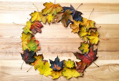 Frame made of autumn leaves on wooden background, top view. Space for text