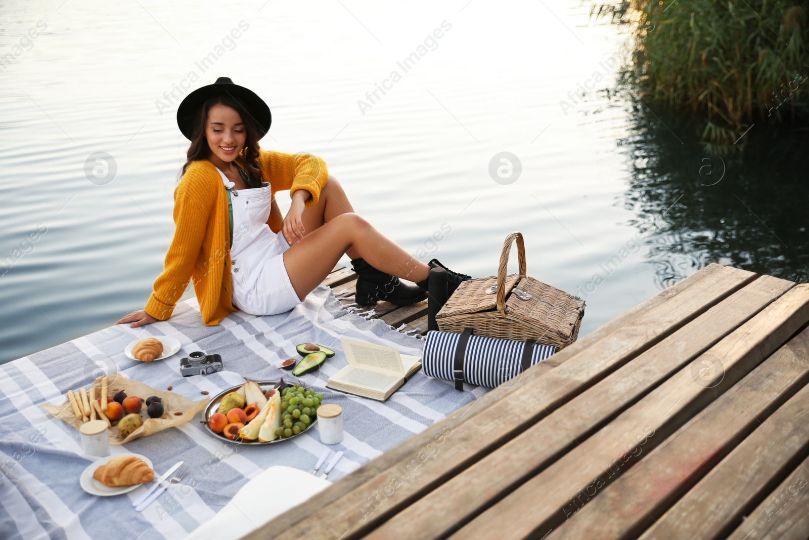 Photo of Young woman spending time on pier at picnic