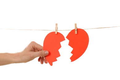 Woman with halves of paper heart on white background. Relationship problems