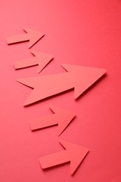 Photo of Many paper arrows on red background, above view