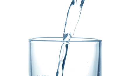 Photo of Pouring water into glass on white background, closeup