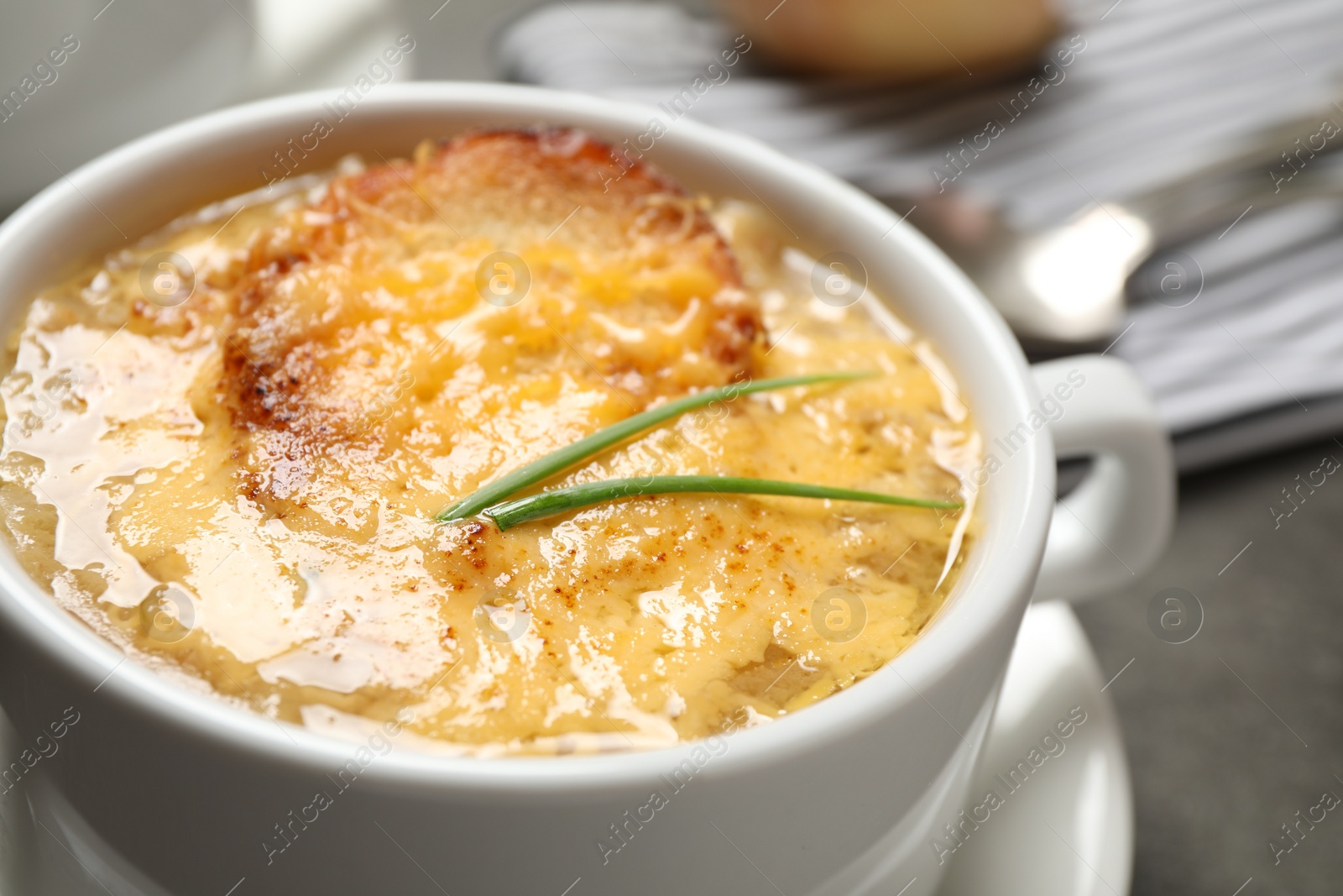 Photo of Tasty homemade french onion soup on table, closeup