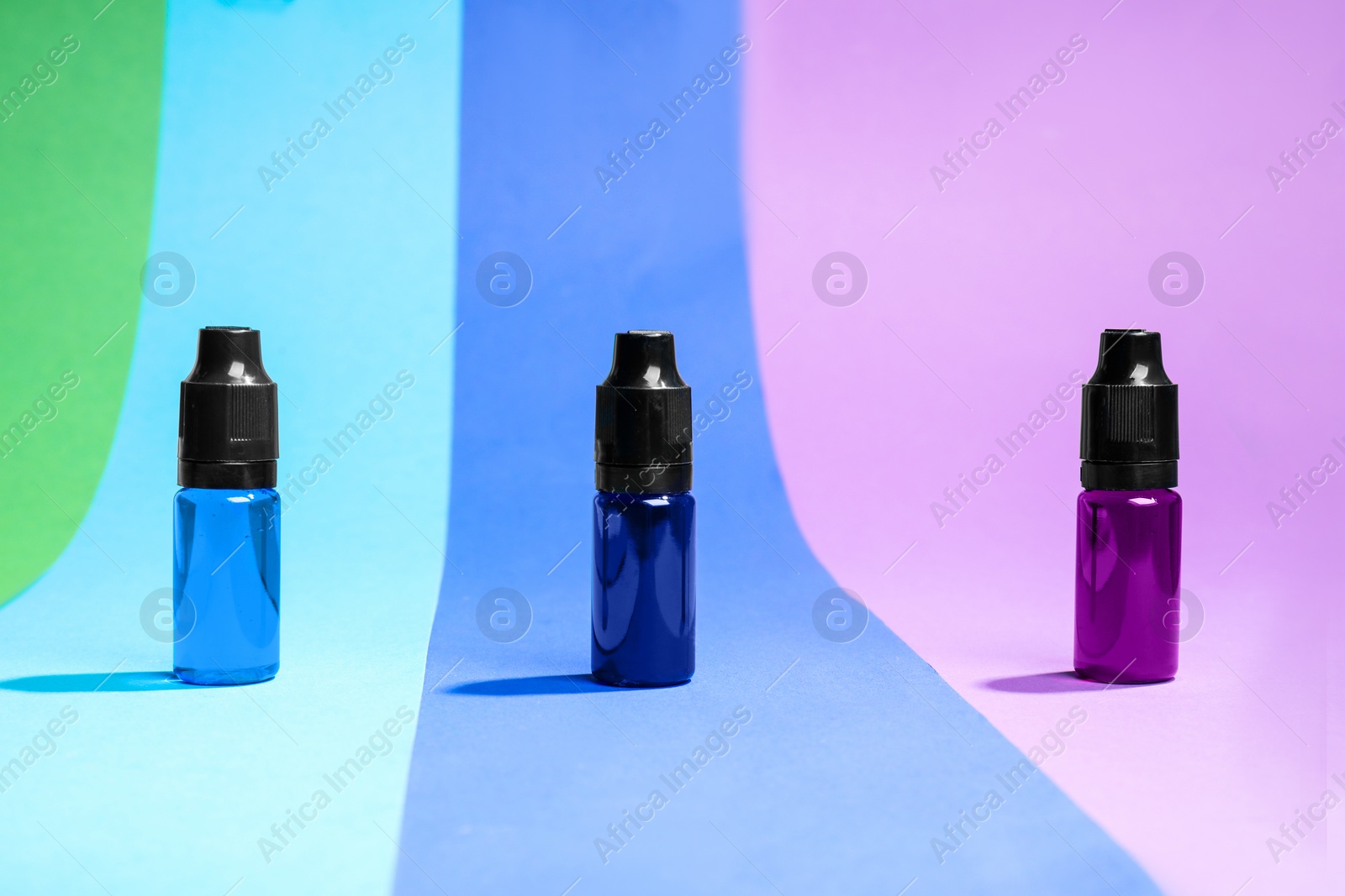 Photo of Bottles with different food coloring on bright background